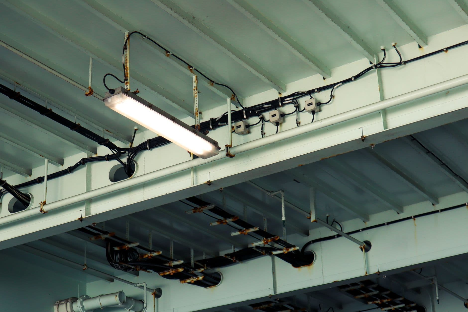 Plafond met tl-armatuur, aansluitdozen en elektrische bekabeling in een technische ruimte