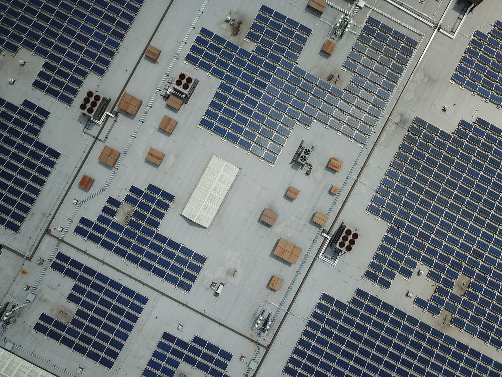 Luchtfoto van een groot plat bedrijfsdak vol zonnepanelen