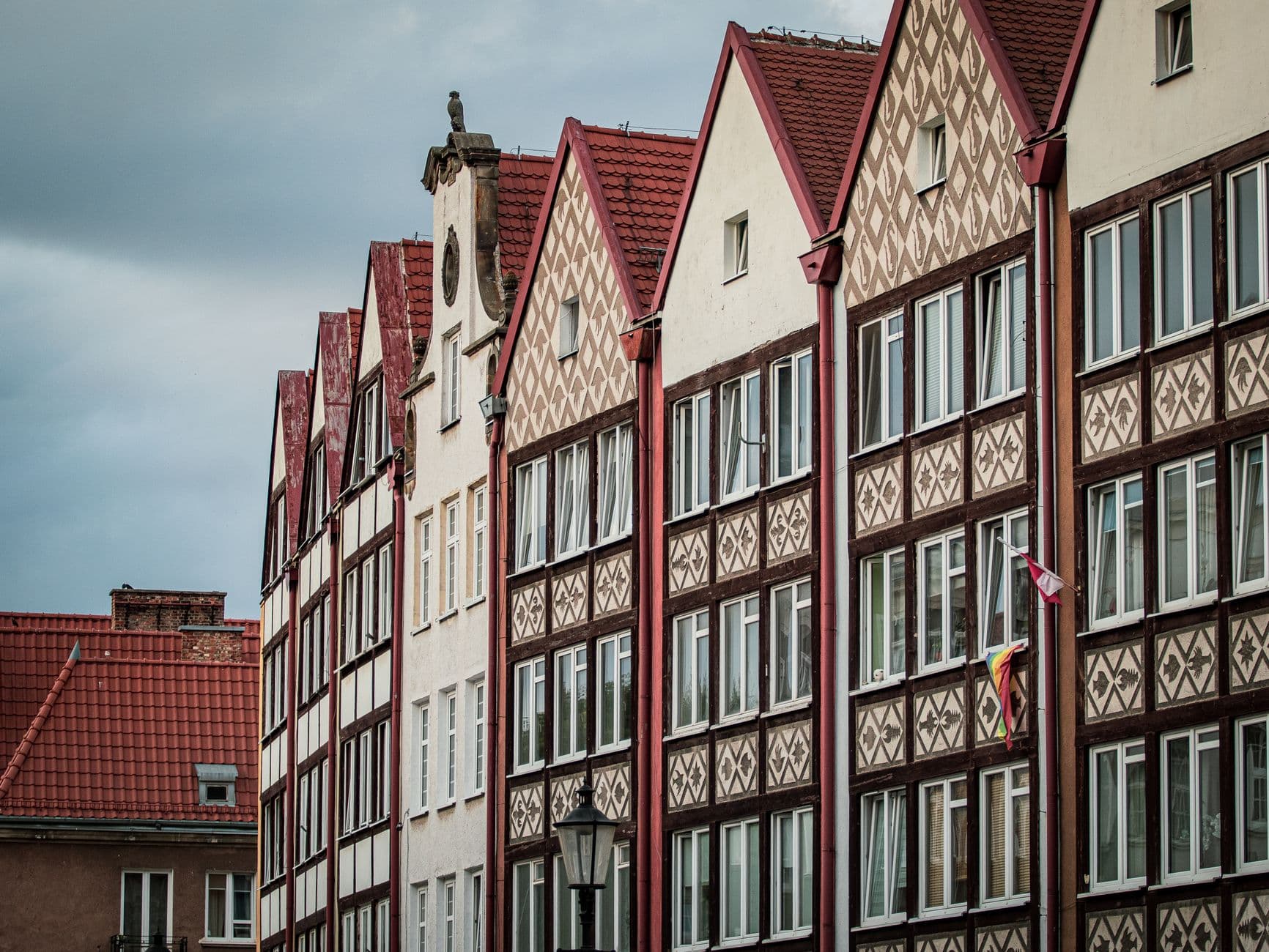 Historische puntgevels met rode pannendaken en bewerkte gevels onder een bewolkte lucht