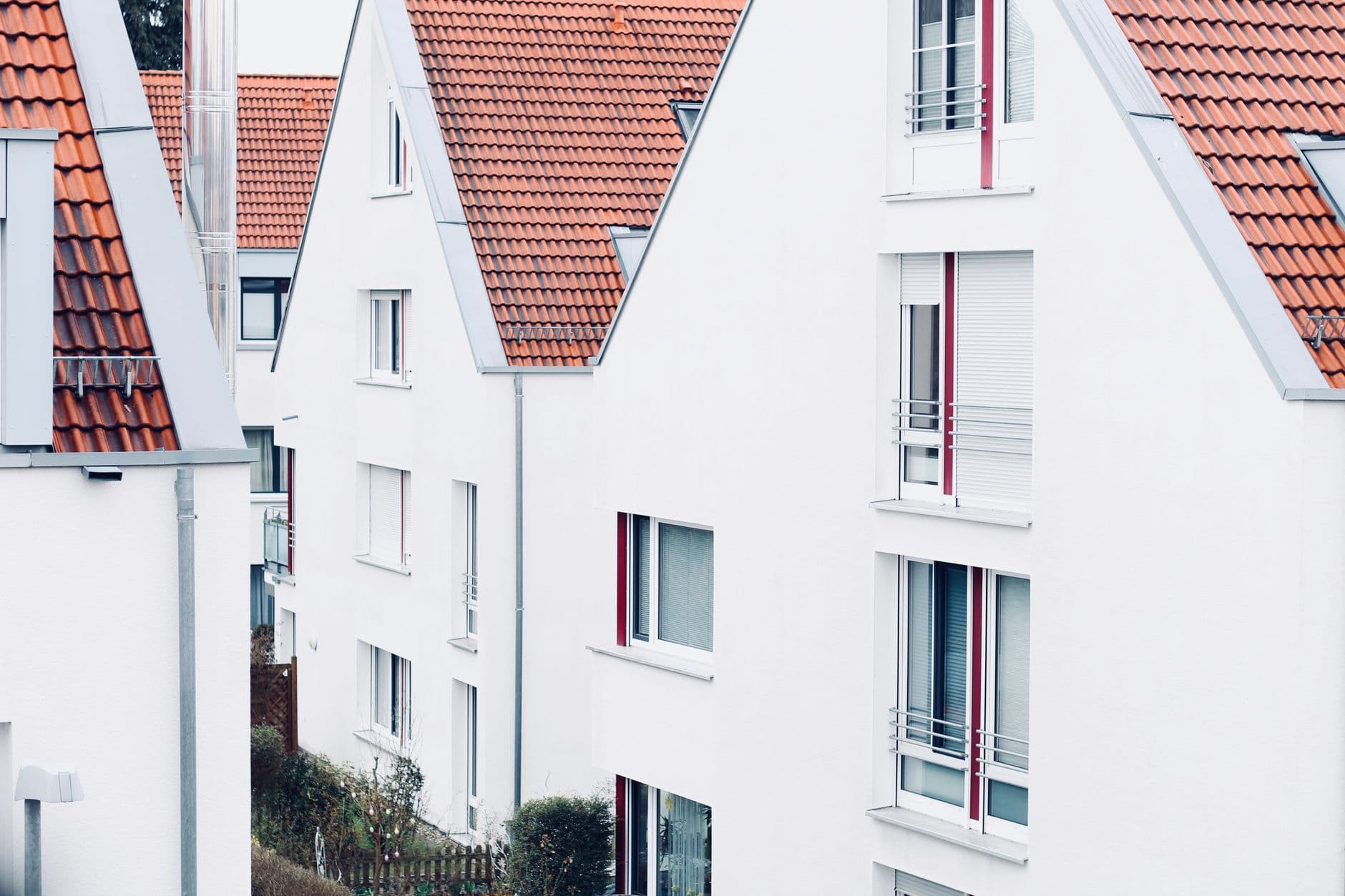 Witte woningen met oranje pannendaken en puntgevels in een rustige woonwijk
