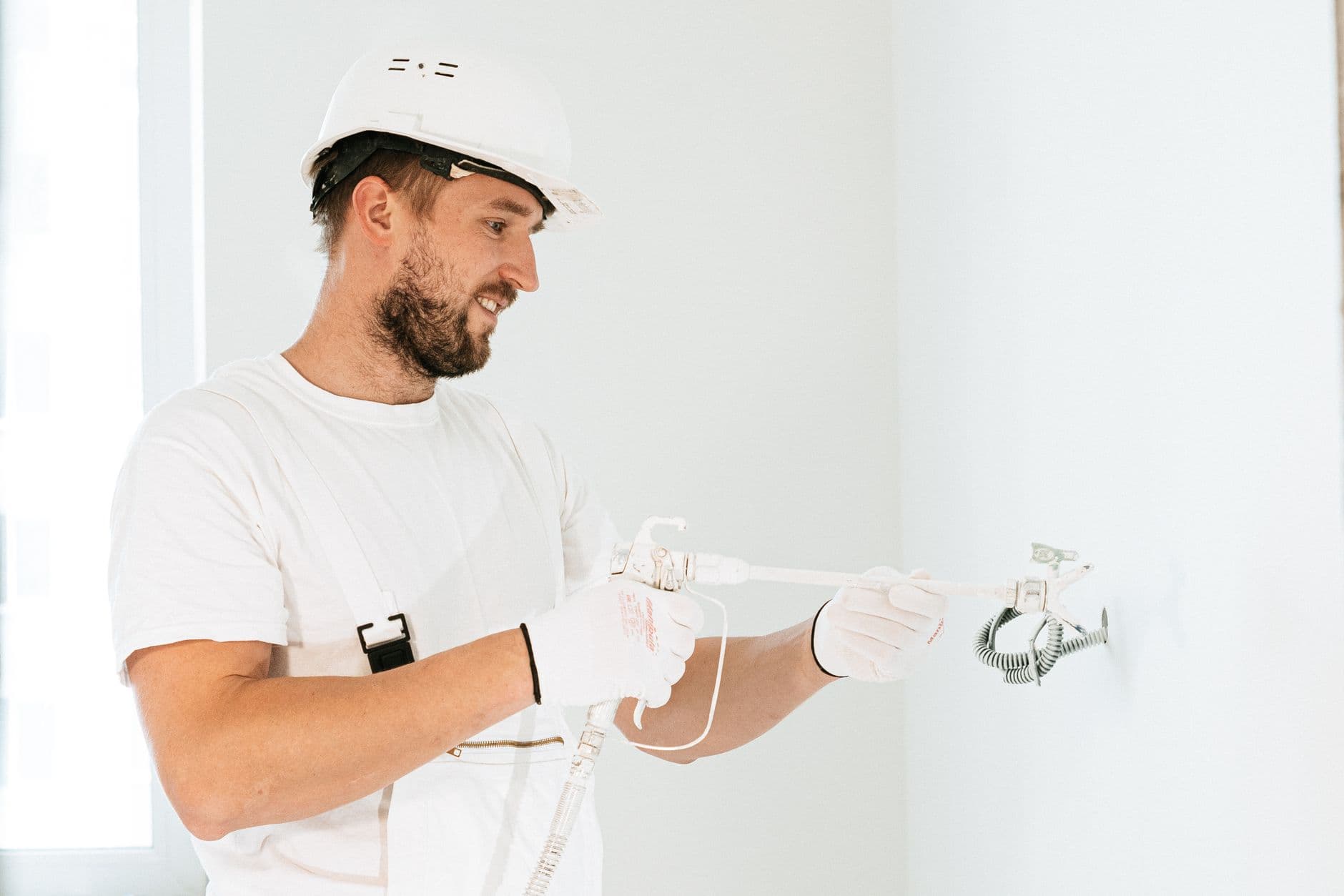Elektricien met veiligheidshelm legt bedrading aan in een nieuwbouw