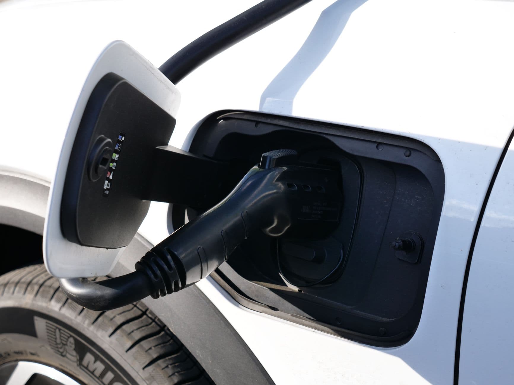 Charging connector plugged into the port of an electric car