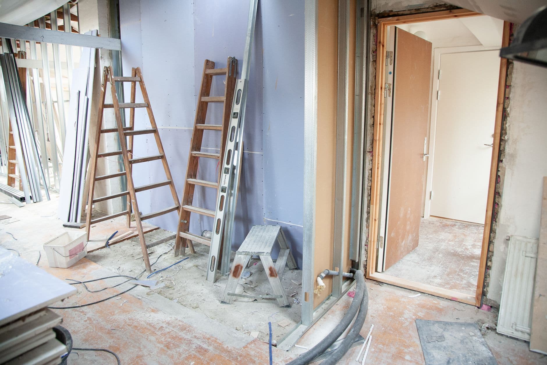 Logement en rénovation avec échelles, ossature métallique de cloisons et câbles au sol