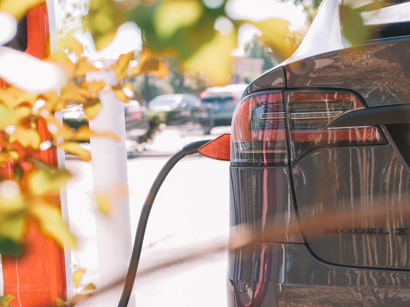 Elektrische auto aan de laadkabel in de herfstzon