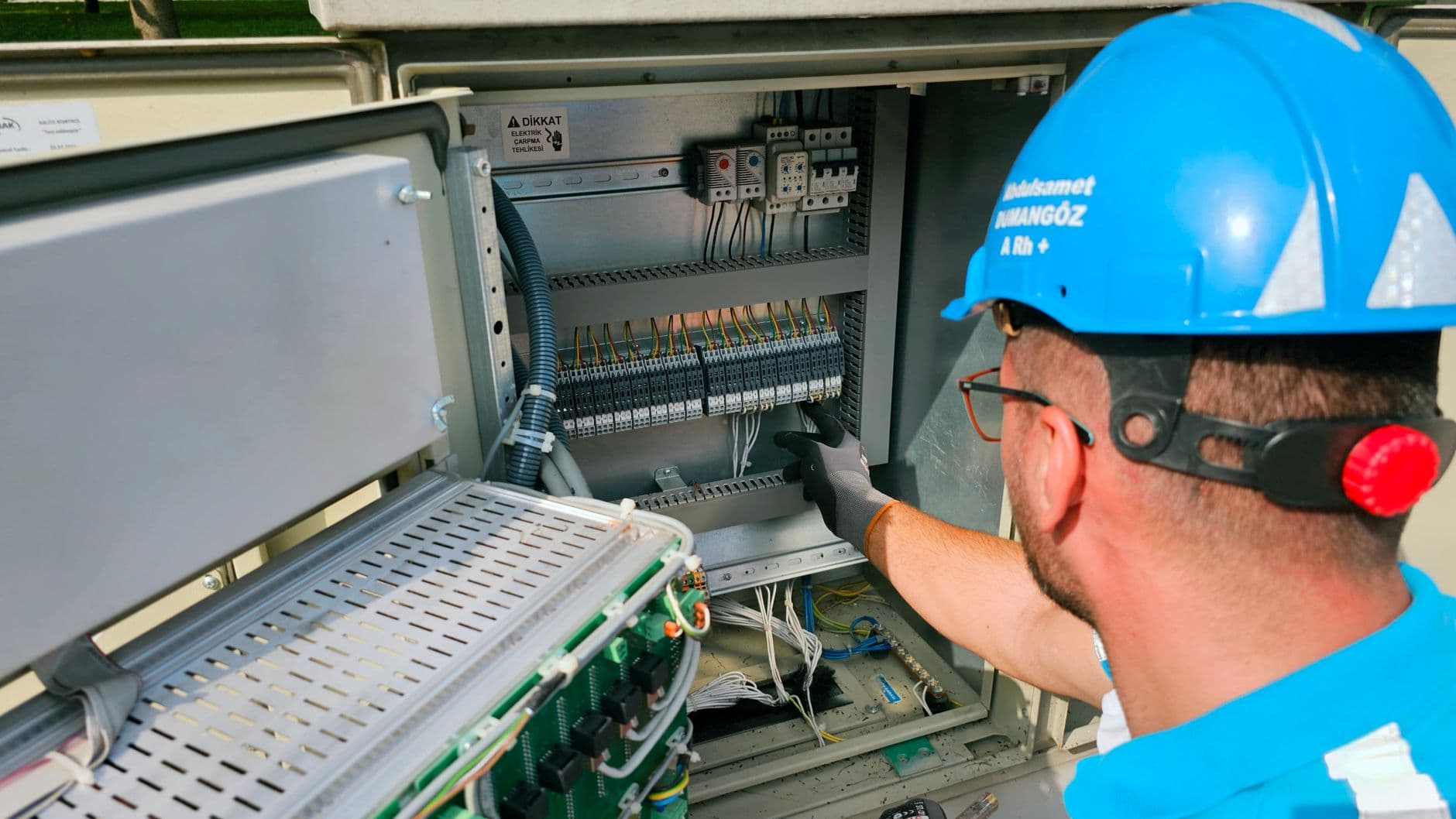 Electrician working on an open fuse box