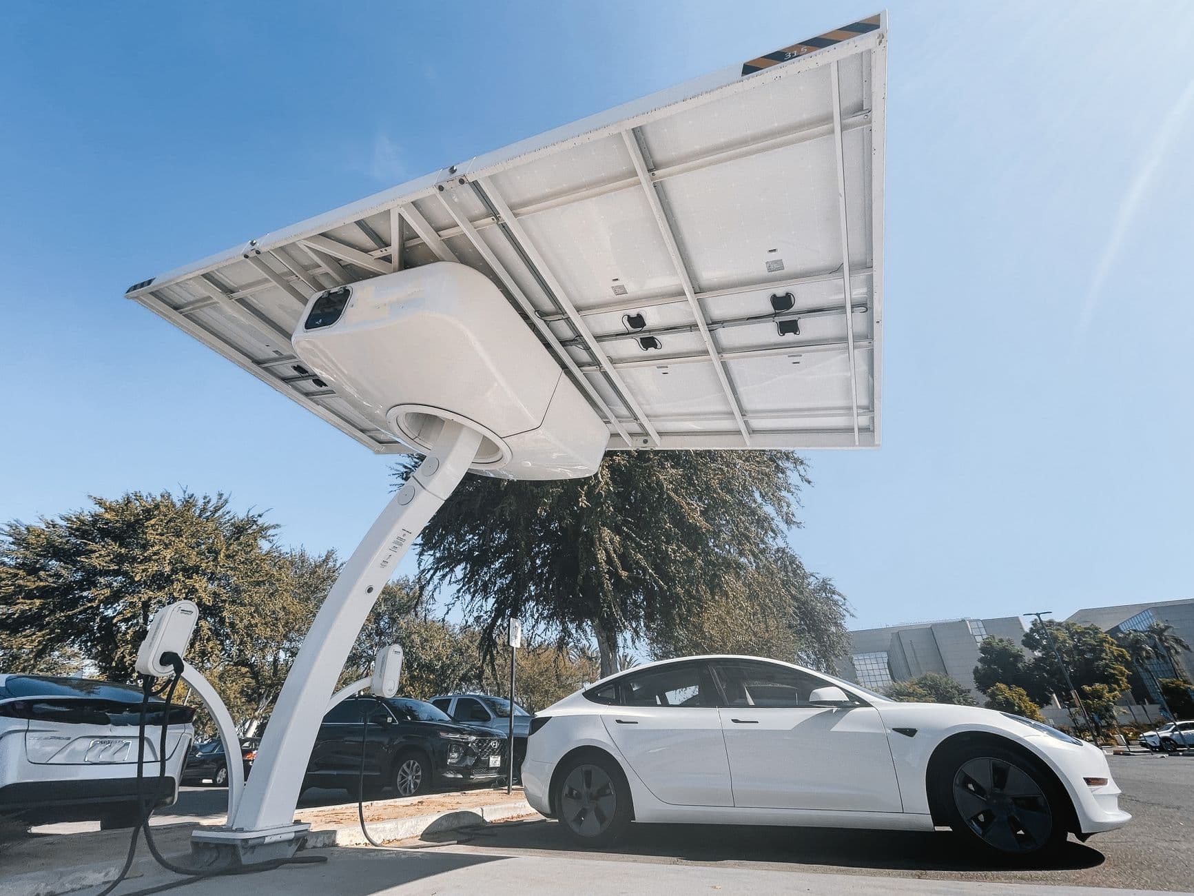 Elektrische auto laadt onder een overkapping met zonnepanelen