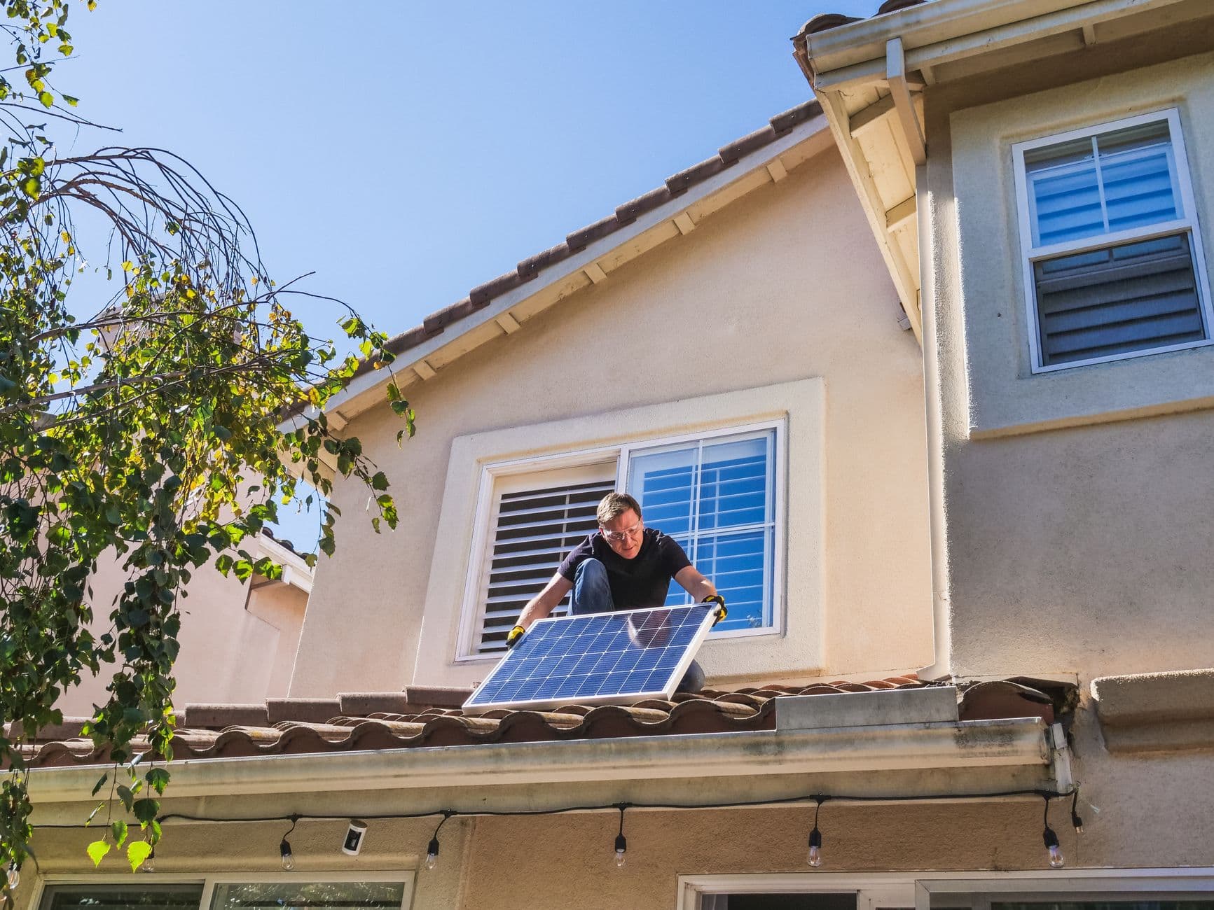 Technician installing solar panels on a sunny roof