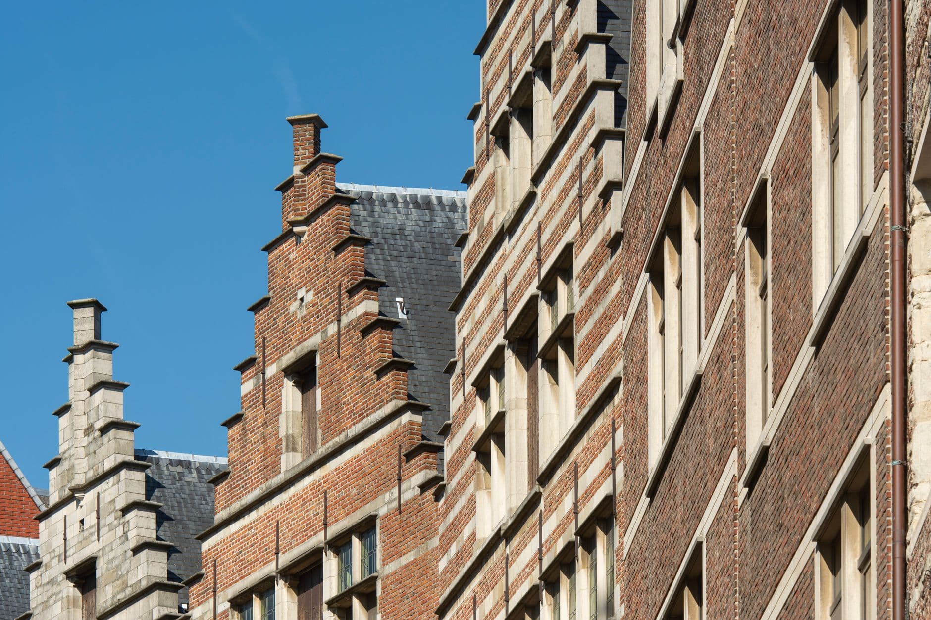 Pignons à gradins en briques de bâtiments historiques à Anvers sous un ciel bleu