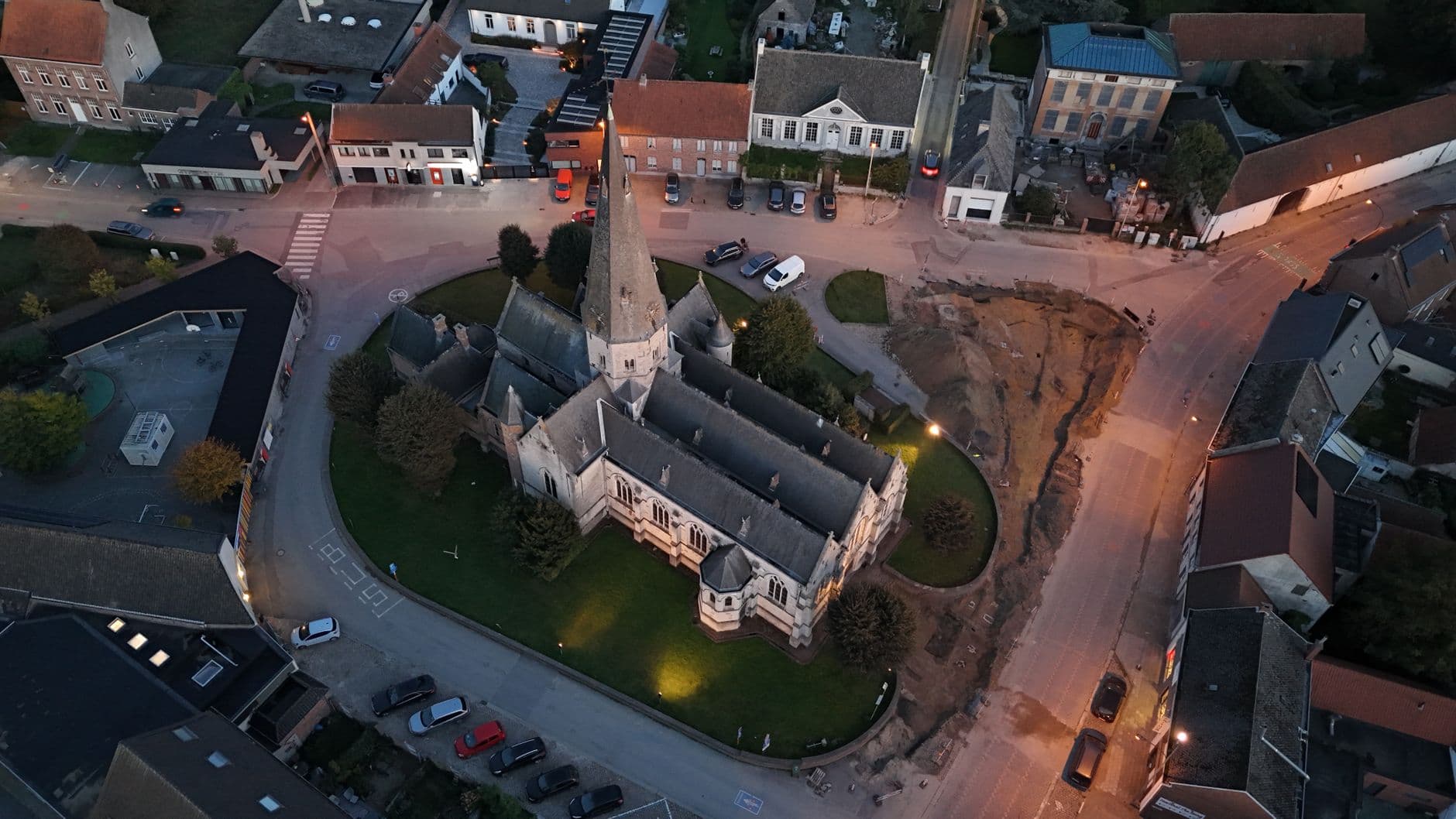 Luchtfoto van de kerk van Gavere en de omliggende huizen bij valavond