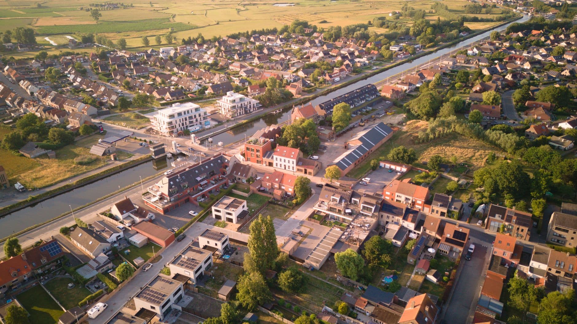 Vue aérienne d'Oudenburg avec des maisons le long du canal, certains toits avec panneaux solaires